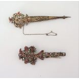 Two Indian ruby and jargoon set turban pins, each with pierced floral decoration, (2).