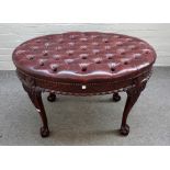 A George II style leather upholstered oval foot stool on mahogany claw and ball feet,