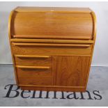 A mid-20th century teak roll top desk with single drawer over cupboard base, 90cm wide x 100cm high.