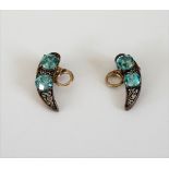 A pair of blue zircon two stone earclips, each in a curved design,