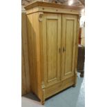 A Victorian style pine double wardrobe with panelled doors flanked by fluted edges on turned