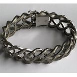 A 9ct white gold wide bracelet of abstract interlinked textured design,
