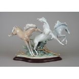 A Lladro porcelain equestrian group 'Born Free' depicting three frolicking horses atop a
