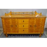 An early 20th century satin birch sideboard, with three drawers flanked by cupboards,