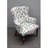 A Victorian style button back easy armchair with Bird of Paradise upholstery, on turned supports,