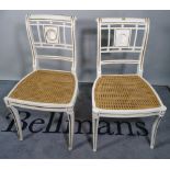 A pair of Regency style white painted side chairs on sabre supports, (2).