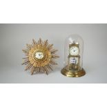 A brass aniversary clock housed under a glass dome,