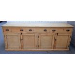 A large Victorian pine dresser base with three frieze drawers over two pairs of cupboards,