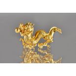 A gold model of a Chinese four clawed dragon, with character marks, length 6cm, weight 34 gms,
