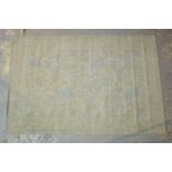 A machine made rug, ivory and blue, 178cm x 117cm.