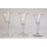 Two plain stemmed wine glasses, each with a teared bell bowl and folded foot, tallest 17.5cm.