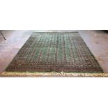 A green Pakistan Bokhara carpet, 306cm x 250cm.