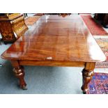 A William IV mahogany extending dining table on lappet carved octagonal baluster supports,