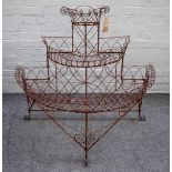 An early 20th century demi-lune three tier wire work plant stand, 114cm wide x 96cm high.