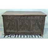 A 17th century and later oak coffer, the twin plank top over carved triple panel front,