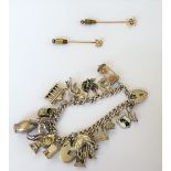 A silver curb link charm bracelet, fitted with a variety of mostly silver charms, including a camel,