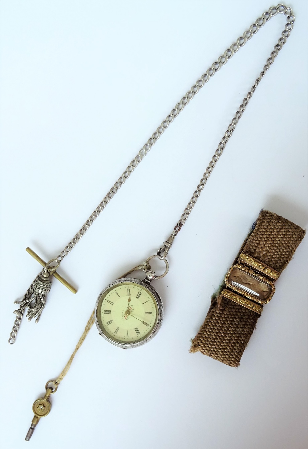 A Victorian woven hairwork bracelet, on a snap clasp, glazed with a woven hair locket compartment,