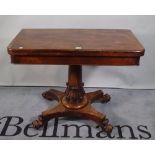 A Victorian rosewood foldover card table with turned central column resting on quatrefoil base,