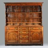 A George III mahogany banded oak dresser, the enclosed three tier shelf back with six spice drawers,