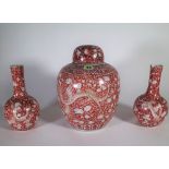 A late 19th/ early 20th century Asian red and white ginger jar decorated with dragons and a pair of