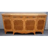 A 20th century walnut breakfront side cabinet with four short drawers over cupboards,