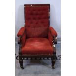 A Victorian mahogany framed armchair with red button back upholstery on tapering supports.