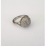 An 18ct white gold and diamond cluster ring, in a bombe design, mounted with circular cut diamonds,