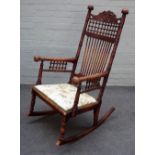 A Victorian Arts & Crafts oak rocking chair, with extensive turned decoration,