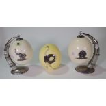 A pair of late 19th early 20th century white metal mounted ostrich eggs on hanging stands and a