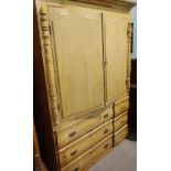 An early 20th century pine double wardrobe with arch panelled doors over three short and three long