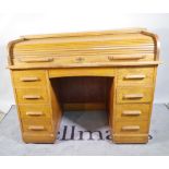 A 20th century oak roll top desk with eight drawers about the knee.