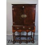 A Queen Anne style figured walnut two door cabinet, on single drawer base,