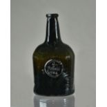 A sealed glass wine bottle, dated 1784, of dark olive-green tint,