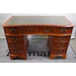 A 20th century yew wood veneered concave pedestal desk with green leather inset top,