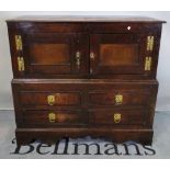 An 18th century oak low cupboard with cupboard top section over four drawers on bracket feet,