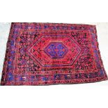 A Hamadan rug, Persian, the hooked madder lozenge with an indigo medallion,