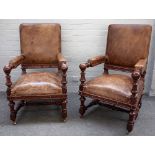 A pair of Victorian brown leather upholstered oak framed open armchairs,