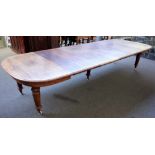 A Victorian mahogany extending dining table on turned fluted supports, five extra leaves,