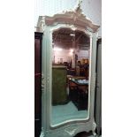 An 18th century style French wardrobe, with scroll crest over bevelled mirror door,