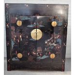An early 20th century Eastern black lacquer polychrome painted two door side cabinet,
