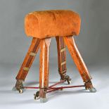 A mid-20th century tan suede upholstered pommel horse on four splayed height adjustable pitch pine