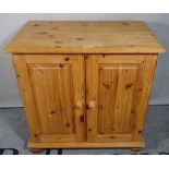 A 20th century pine side cupboard with a pair of panelled doors, 81cm wide x 72cm high.