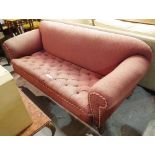 A late Victorian mahogany framed Chesterfield style sofa with pink button back upholstery,