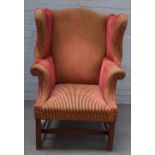 A George III style wingback armchair, on chanelled square supports, 89cm wide x 120cm high.