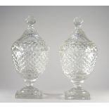 A pair of cut glass urns and covers, 19th century, each cut with bands of raised diamonds,