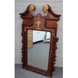 A George II style parcel gilt mahogany mirror with swan neck pediment, 70cm wide x 126cm high.