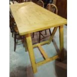 A 20th century pine work table on folding 'A' frame supports, 172cm wide x 80cm high.