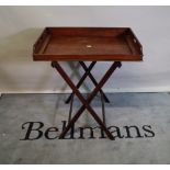 A late 19th century mahogany butlers tray with galleried top and folding stand,