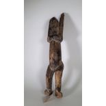 A Dogan tribal wooden figure, depicted standing with arms outstretched (a.f.), 71cm high.