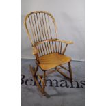 A 20th century ash and elm stick back rocking open armchair.